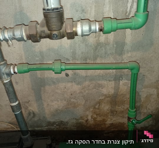 צנרת ירוקה עם שסתום וברז על קיר בטון